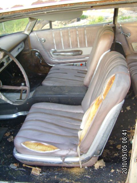 1963 Ford Galaxie - The interior of an old car shows significant wear and tear on the seats and door panels.