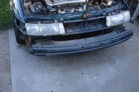 1993 Ford Taurus - Front view of a 1993 Ford Taurus showing the engine bay and missing bumper.