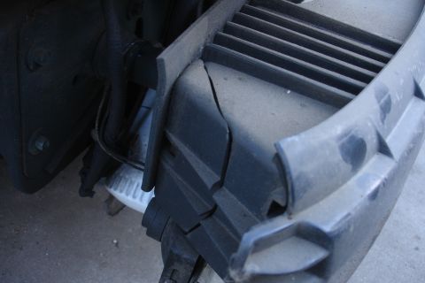 1993 Ford Taurus - Close-up view of a damaged vehicle bumper and grille, showing cracks and wear.