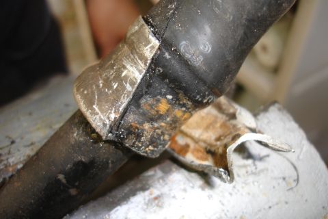 1995 Ford Taurus - A close-up view of a corroded hose clamp attached to a black hose, showing signs of wear and tear.