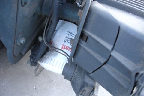 1993 Ford Taurus - Close-up view of a white oil filter with visible text and surrounding engine parts.