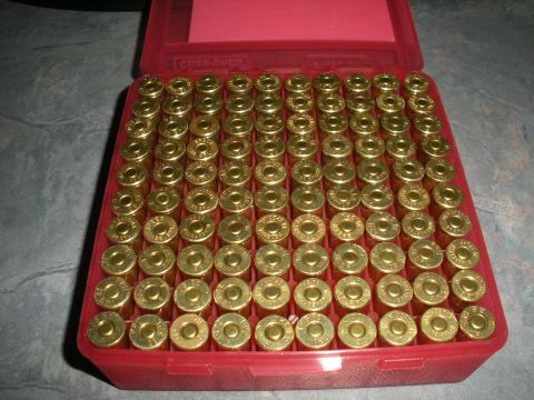 1996 Ford Bronco - A red ammo box is filled with numerous brass cartridges, ready for reloading or casting.