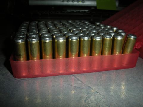 1996 Ford Bronco - A red plastic holder contains numerous brass cartridges with silver tips.