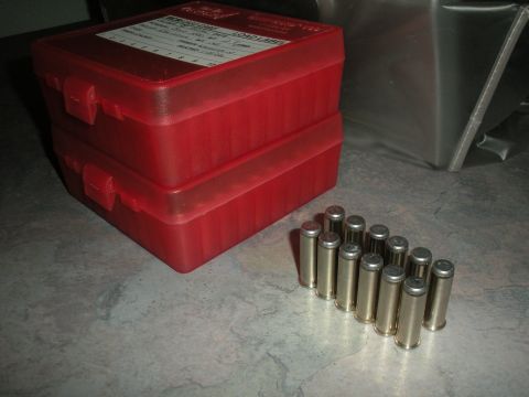 1996 Ford Bronco - A close-up view of ammunition reloading supplies, including two red plastic cases and several bullets.