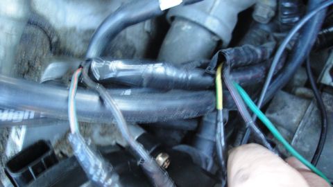 1995 Ford Probe - Close-up view of a vehicle's engine wiring harness, showing exposed wires and electrical tape.