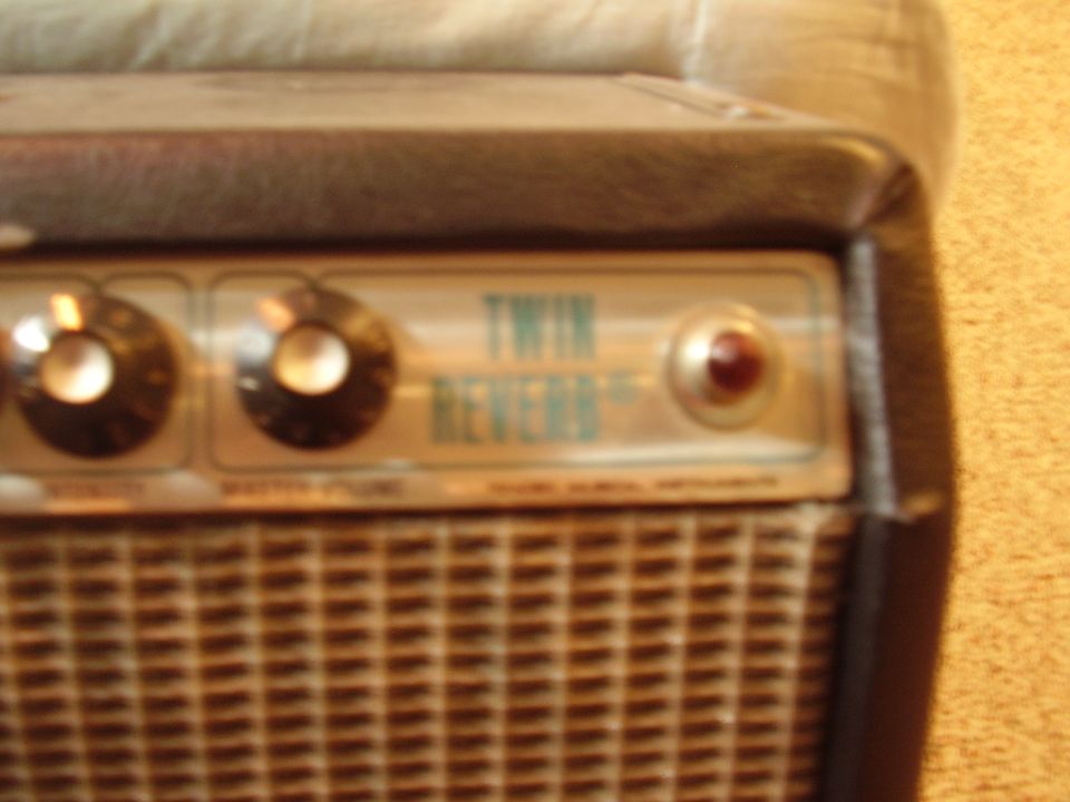 Close-up of a Fender Twin Reverb amp's control panel with two knobs, a red indicator light, and the 'TWIN REVERB' text