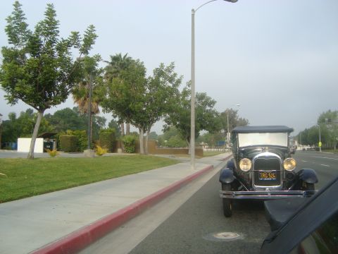 1986 Ford Bronco - A vintage Ford Model A is parked curbside, its classic design evident from the front.