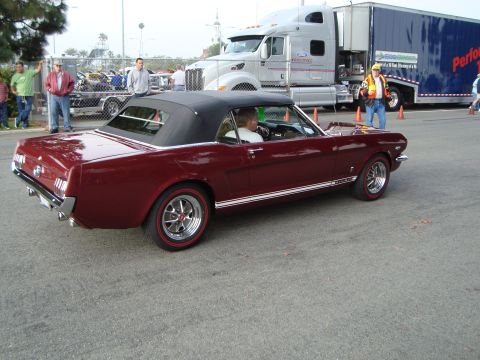 1986 Ford Bronco - A classic maroon convertible is parked on asphalt with a large semi-truck in the background.