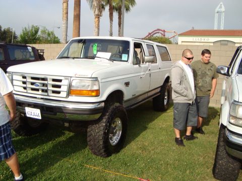 1986 Ford Bronco - This white SUV, likely a 1992 model, is shown with a lifted suspension and oversized tires.