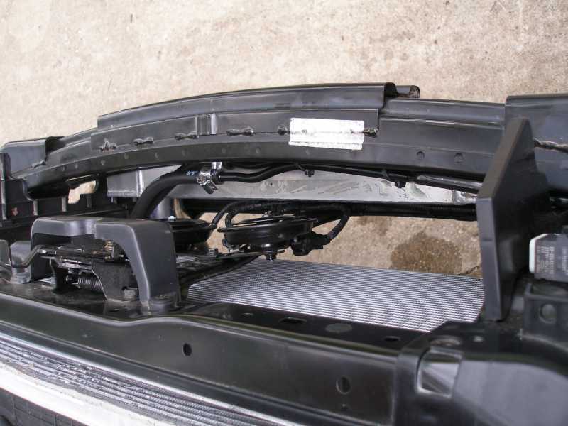 Relocated finned cooler mounted behind a black crash bar on a car with bumper removed