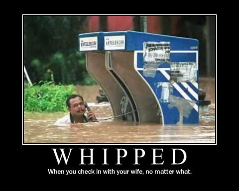 1989 Ford Bronco - A man stands in floodwaters, talking on a phone next to a submerged blue structure.
