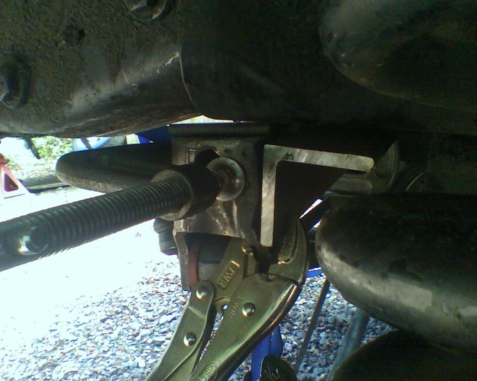 close-up of vehicle suspension component with vise grips attached