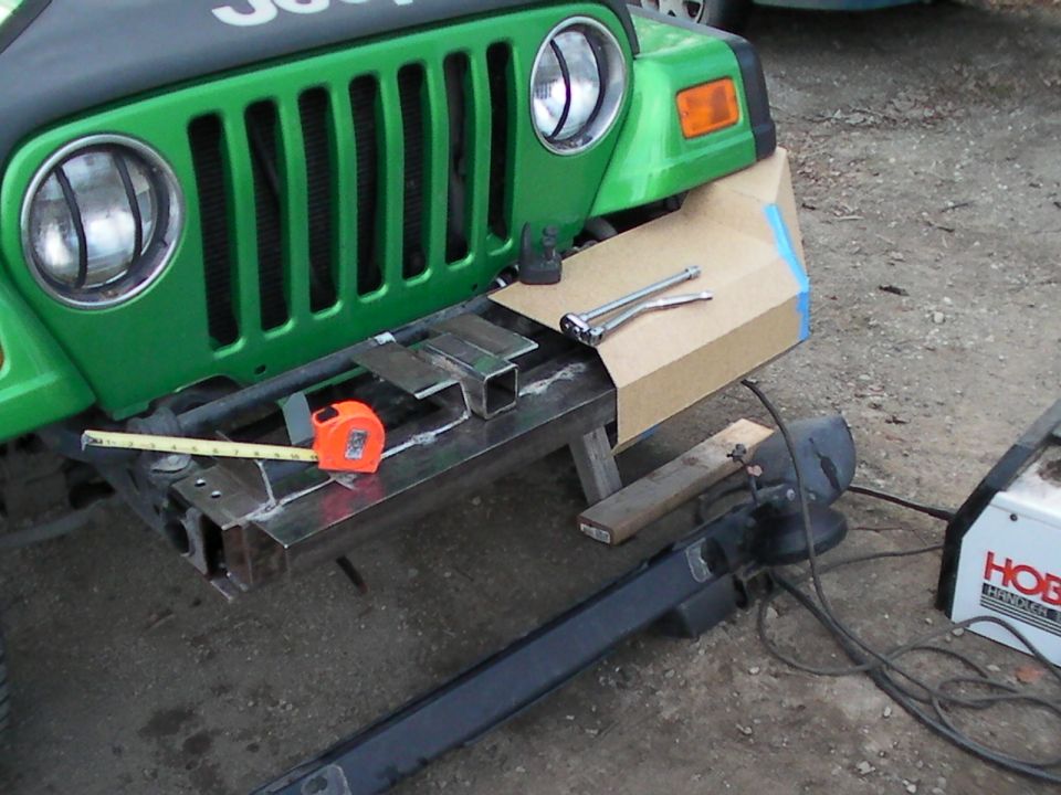 Green Jeep front bumper modification with welding equipment and tools