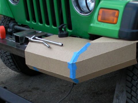 1987 Suzuki Samurai - A cardboard mockup of a custom bumper is taped to the front of a green Jeep.