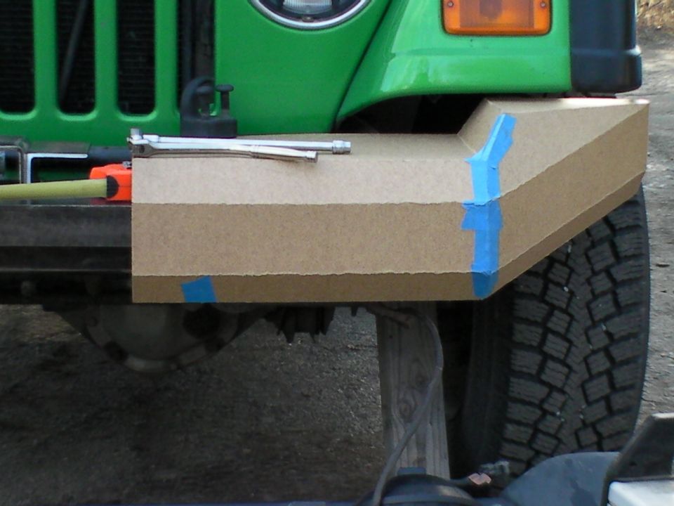 Cardboard bumper mockup with blue tape on front of green off-road 4x4