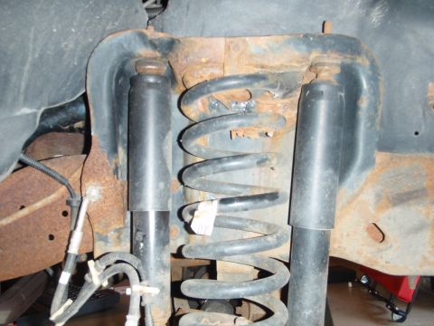 1995 Ford Bronco - Close-up view of the front suspension system, showing coil springs and shock absorbers.