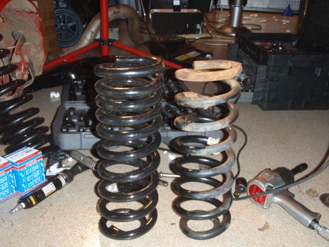 1995 Ford Bronco - Comparison of new and old suspension springs with automotive tools laid out.