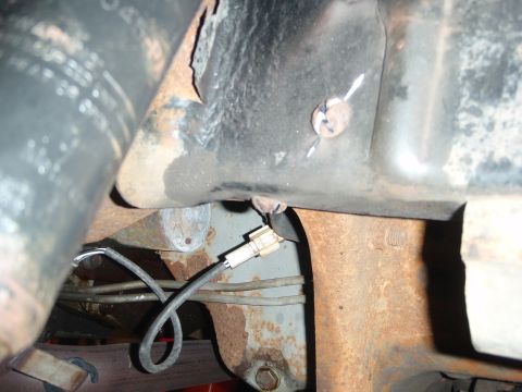 1995 Ford Bronco - A close-up view of a vehicle's undercarriage reveals rusty components and a visible wiring harness.