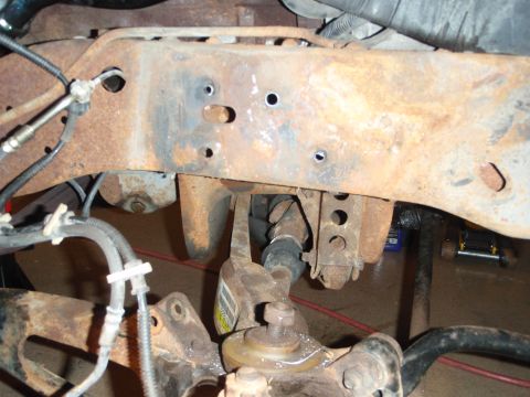 1995 Ford Bronco - Rusted frame and suspension parts of a vehicle, likely undergoing repair or restoration.