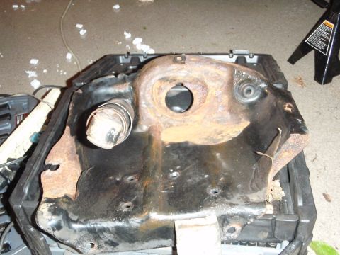 1995 Ford Bronco - This heavily rusted metal component appears to be a part of a vehicle's frame or suspension system.
