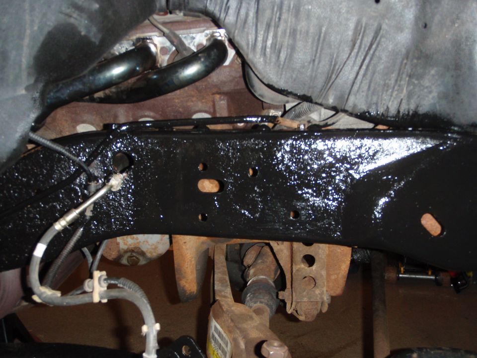 Black painted vehicle frame with exhaust manifold and drive shaft visible