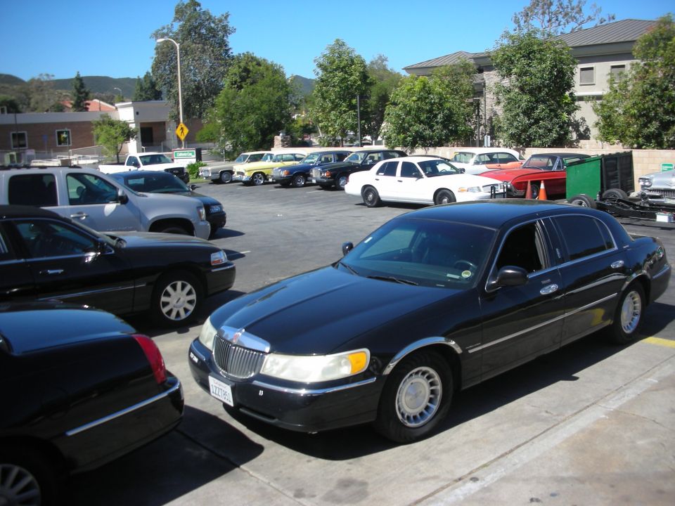 Black Lincoln Town Car with chrome trim, parked in a lot