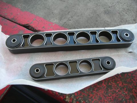 2004 Ford Crown Victoria - Two aftermarket suspension components are laid out on white paper.