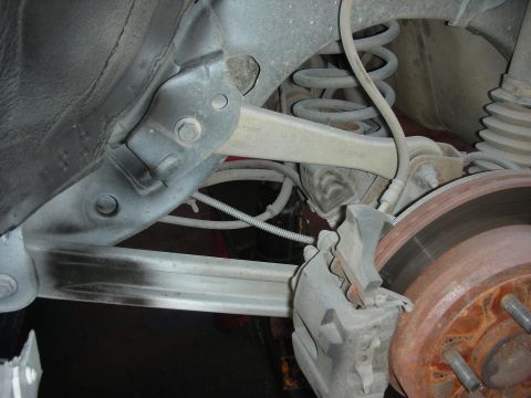 2004 Ford Crown Victoria - Close-up view of the rear suspension control arm on a 2004 Ford Crown Victoria, showing the Ford branding.