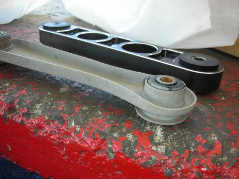 2004 Ford Crown Victoria - Comparison of a stock control arm next to an aftermarket performance control arm.