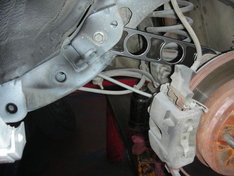 2004 Ford Crown Victoria - The photo shows a close-up view of a vehicle's rear suspension system, focusing on the control arm and brake components.