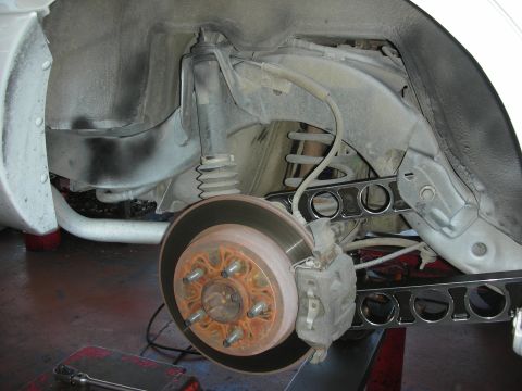 2004 Ford Crown Victoria - The rear suspension of a 2004 Ford Crown Victoria shows a rusty brake rotor and modified control arms.