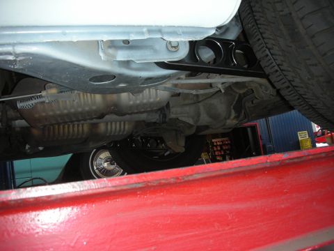2004 Ford Crown Victoria - The undercarriage of a vehicle is viewed from below, revealing the exhaust and suspension components.