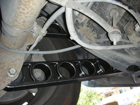 2004 Ford Crown Victoria - Close-up of an aftermarket rear control arm, showing its custom design and installation.