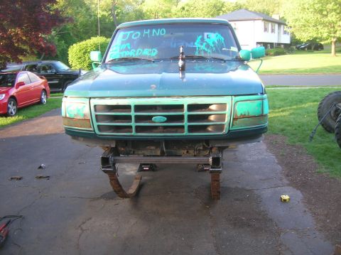 1996 Ford Bronco - A green Ford truck is shown from the front, modified with custom suspension and a beer bottle on the hood.