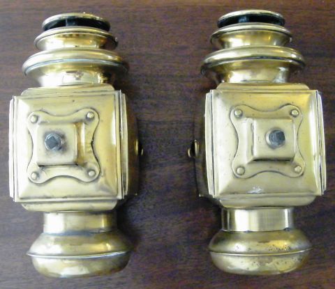 1912 Ford Model T - A pair of vintage brass carriage lamps are displayed on a wooden surface.