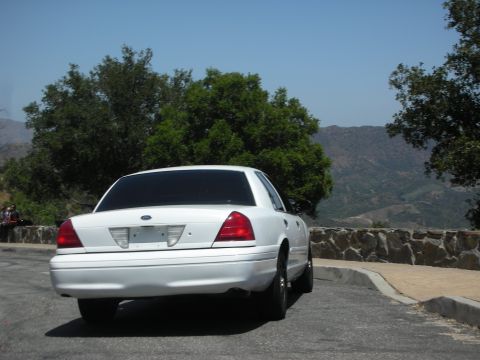 2004 Ford Crown Victoria - Rear view of a white sedan parked on a scenic overlook.