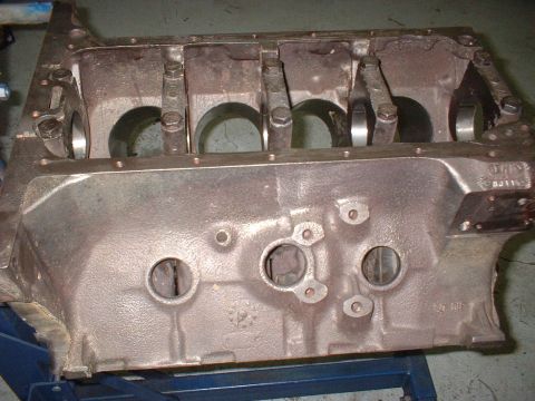 1969 Ford Torino - Engine block with connecting rods visible inside cylinder bores, resting on a blue stand.