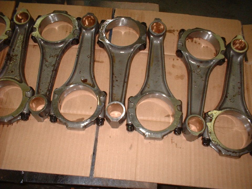 Set of engine connecting rods laid out on cardboard