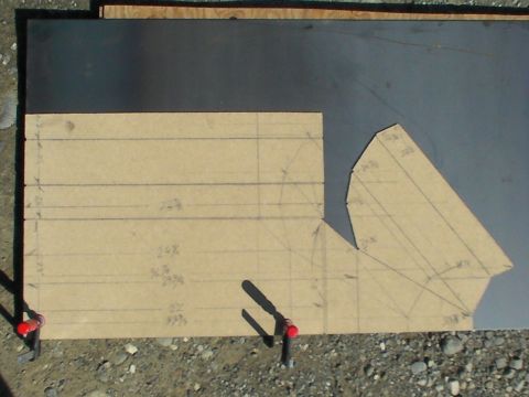 1987 Suzuki Samurai - A cardboard template with measurements and lines is clamped to a dark sheet of metal, likely for a custom part.