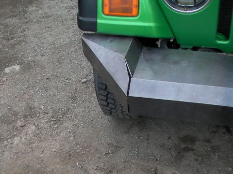 1987 Suzuki Samurai - The front corner of a green 1987 Suzuki Samurai features a custom-fabricated metal bumper.