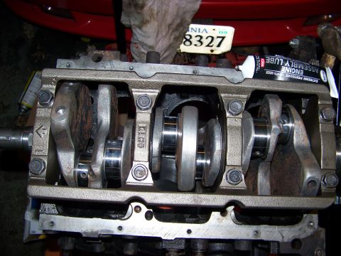 1991 Mitsubishi 3000GT - Close-up of an engine's crankshaft assembly, with a tube of engine assembly lube resting on the block.