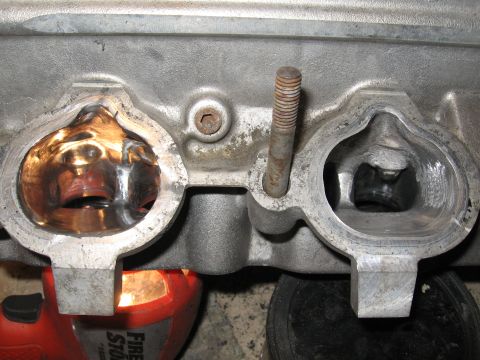 1991 Mitsubishi 3000GT - Engine cylinder head ports shown in detail with a bolt protruding.