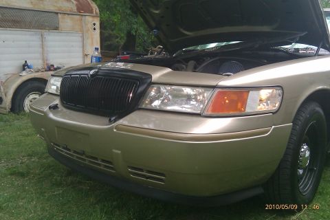 2000 Mercury Grand Marquis - Front view of a gold 2000 Mercury Grand Marquis with its hood open, parked on grass.
