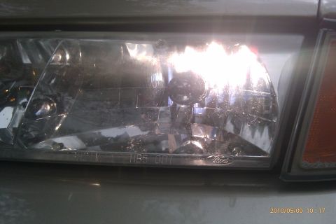 2000 Mercury Grand Marquis - A close-up view of a car's headlight assembly, showing the clear lens and internal components.