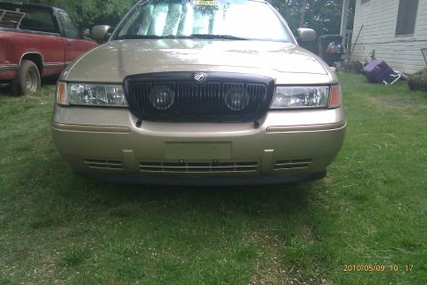 2000 Mercury Grand Marquis - Front view of a gold 2000 Mercury Grand Marquis, its distinctive black grille and headlights.