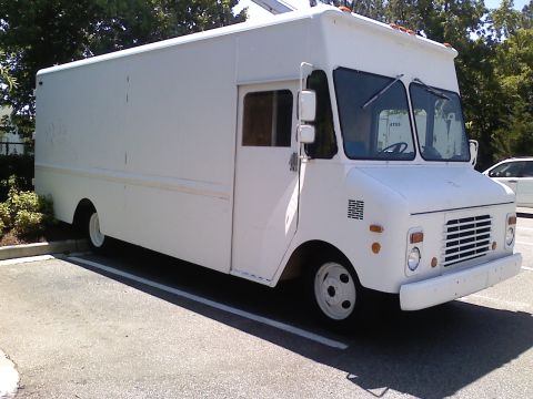 1989 Ford Bronco - This white step van is parked in a lot, showing its front quarter.