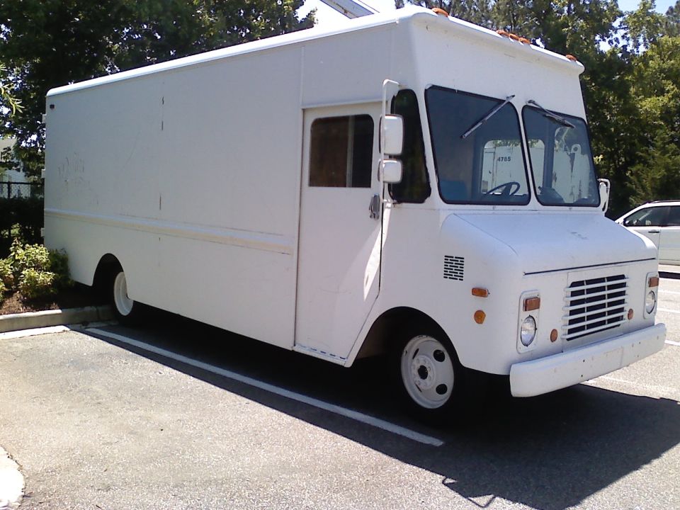 White step van parked in a lot, front quarter view