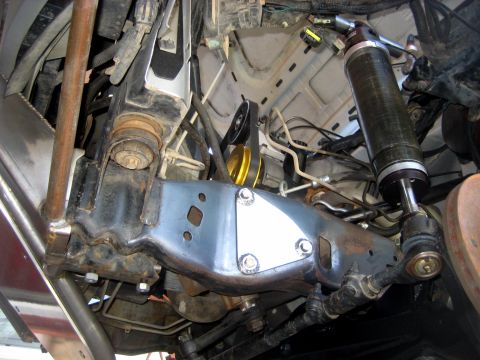 1996 Ford Bronco - Underside view of modified front suspension components, including a large shock absorber and custom bracing.