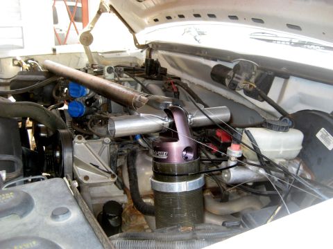 1996 Ford Bronco - Custom suspension component installed in the engine bay of a white vehicle.