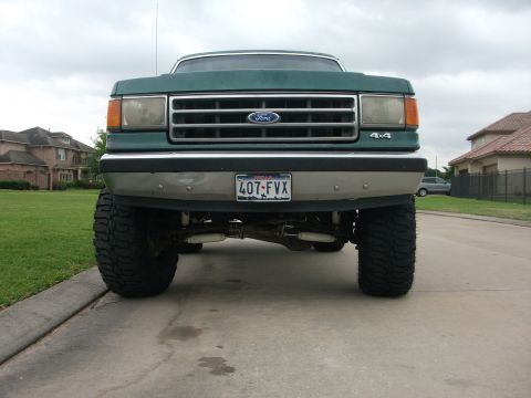 1989 Ford Bronco - Front view of a lifted green Ford Bronco with 4x4 badging on the grille.